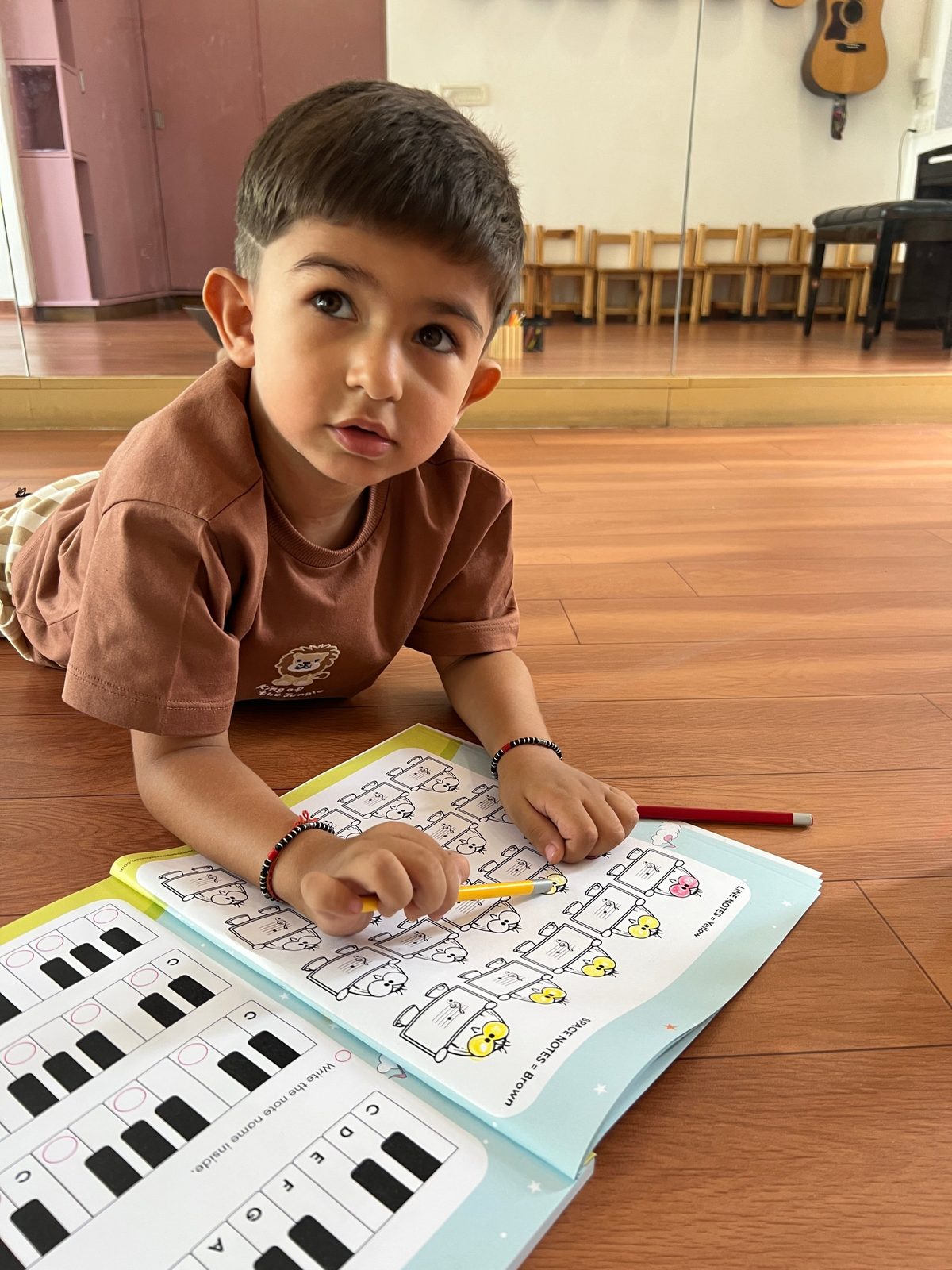 A boy colouring a music notes workbook